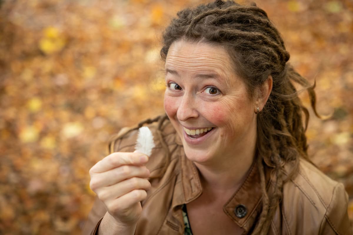 Inge houdt met een ondeugende grijns een wit veertje omhoog